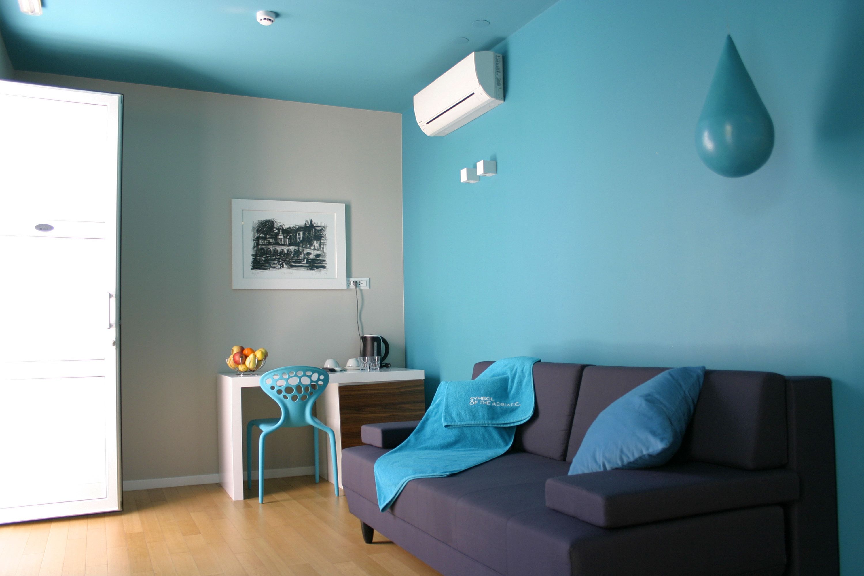 Una sala de estar moderna con un sofá, una mesa de centro, una silla y un escritorio.