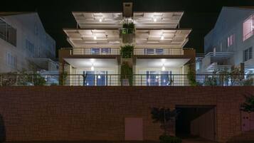A multi-story residential building with balconies and a brick facade.