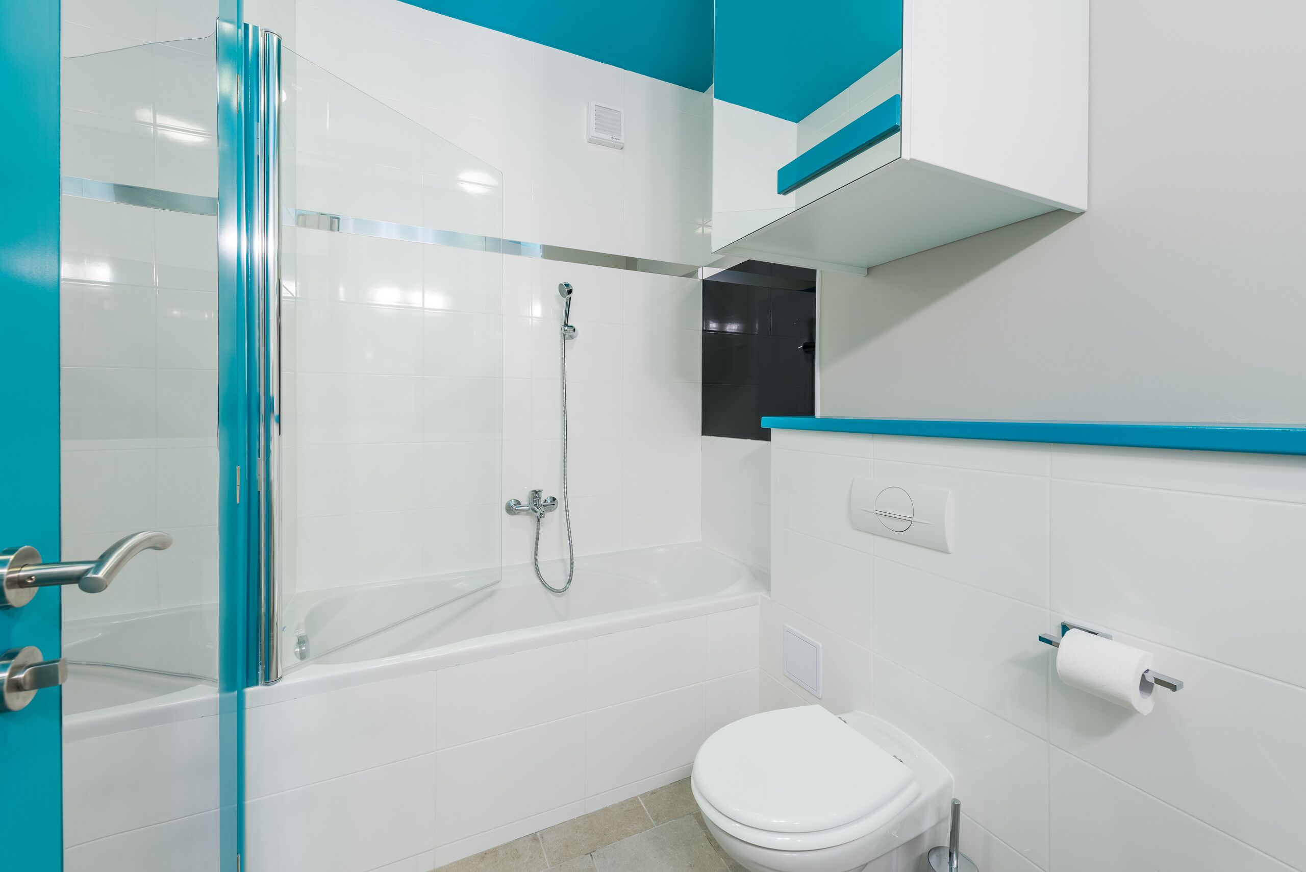 A modern bathroom with a glass shower enclosure, a white bathtub, and a toilet.