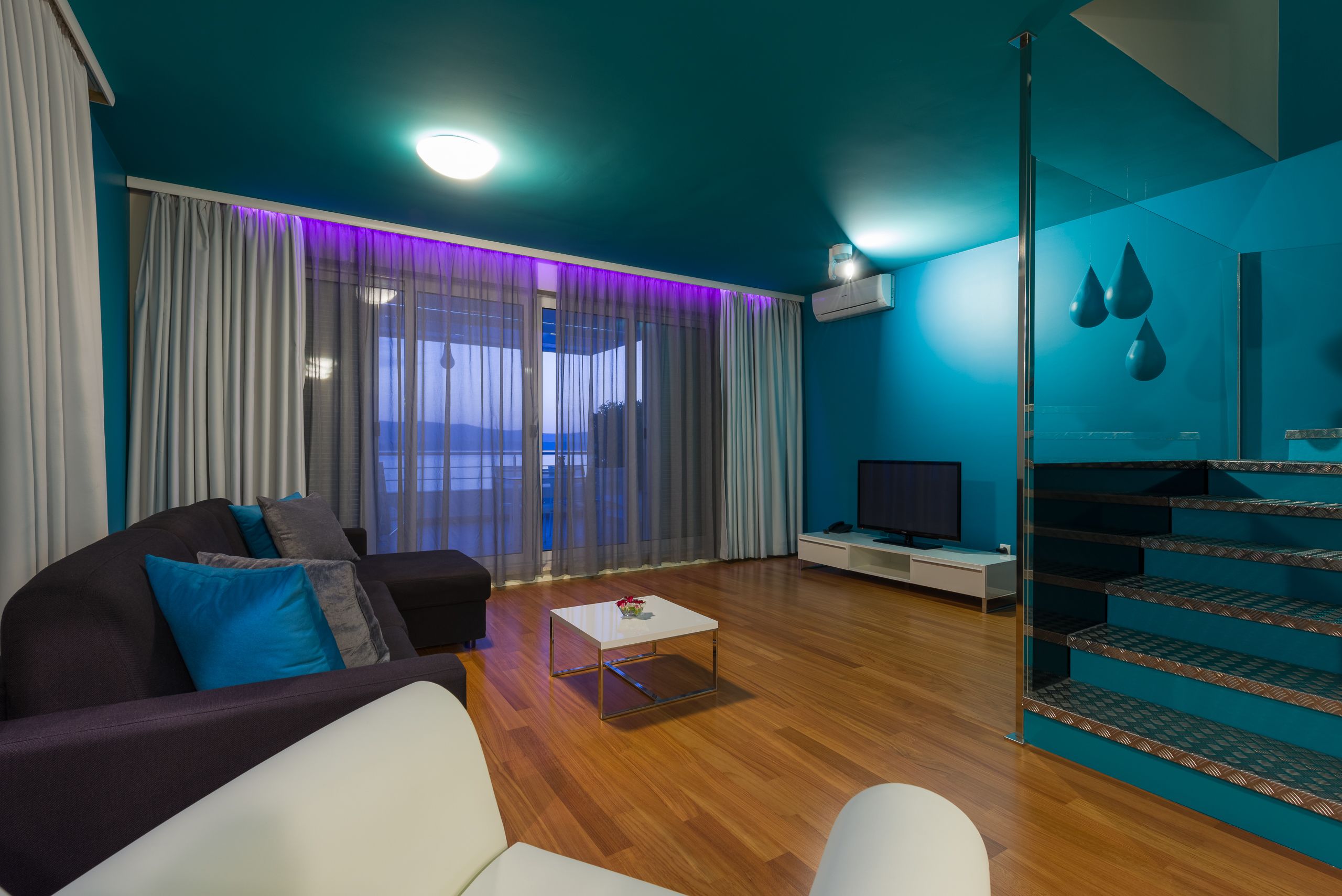 Un salon moderne avec un canapé, une table basse et un téléviseur.