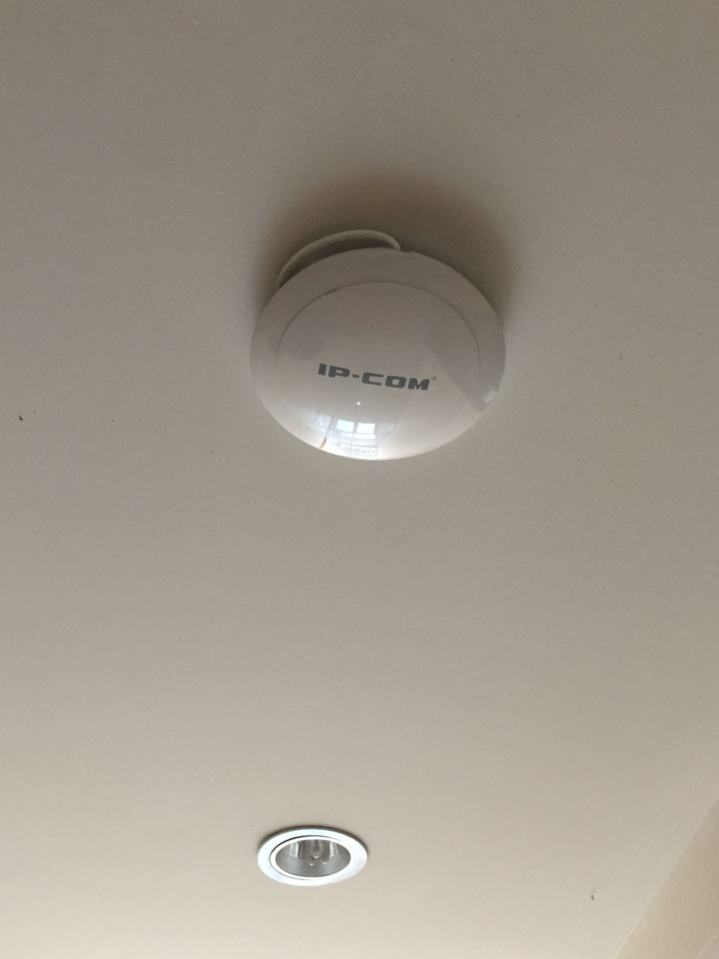 A ceiling with a smoke detector and a light fixture.