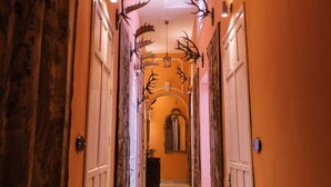 A hallway with ornate antler decorations on the walls and ceiling, leading to a mirrored room. - Palacio del Virrey Laserna (Jerez de la Frontera)