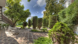 A courtyard with a tiled floor, potted plants, and neatly trimmed hedges. - Palacio del Virrey Laserna (Jerez de la Frontera)