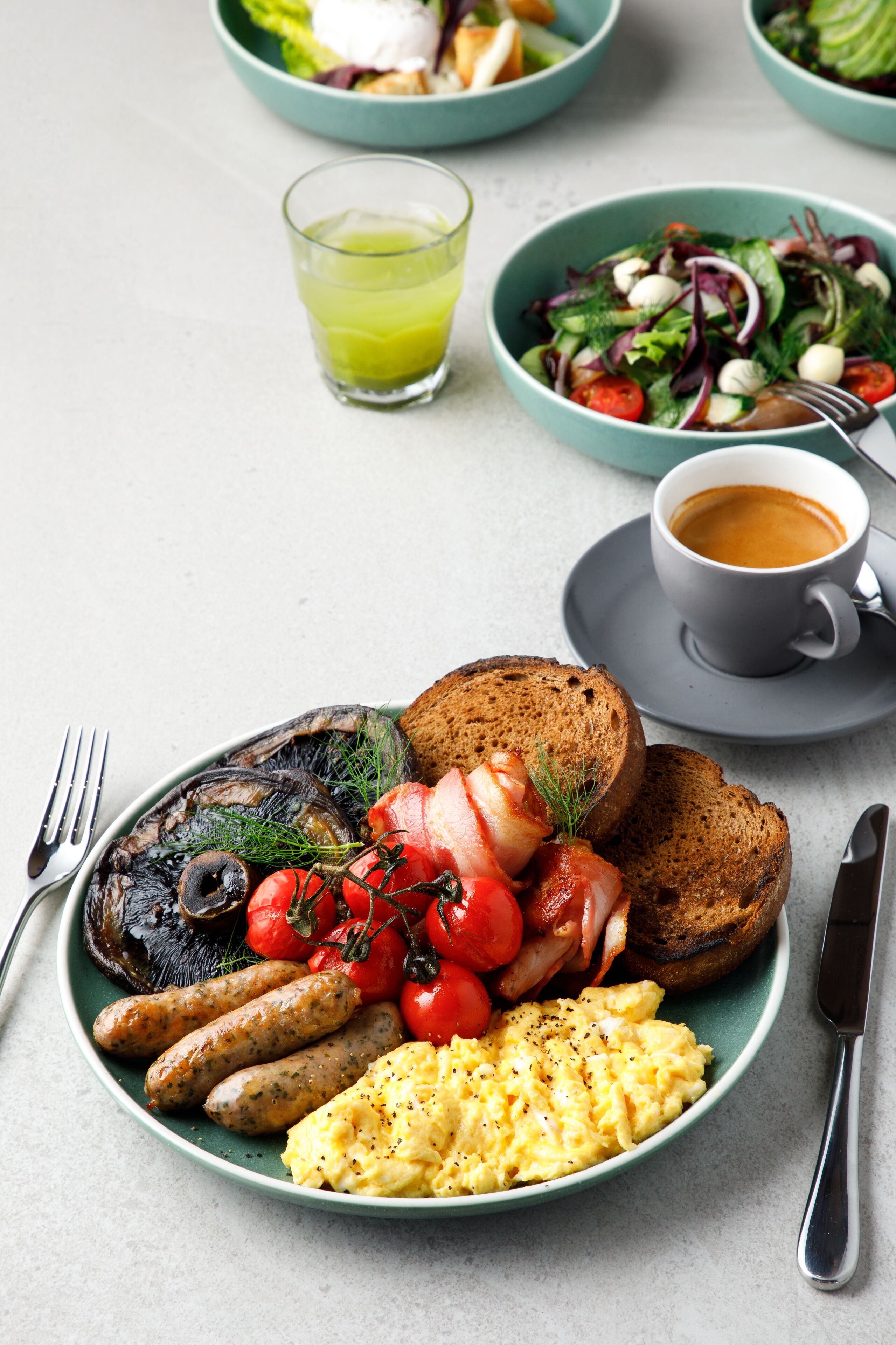 A breakfast plate with eggs, sausages, tomatoes, and toast.
