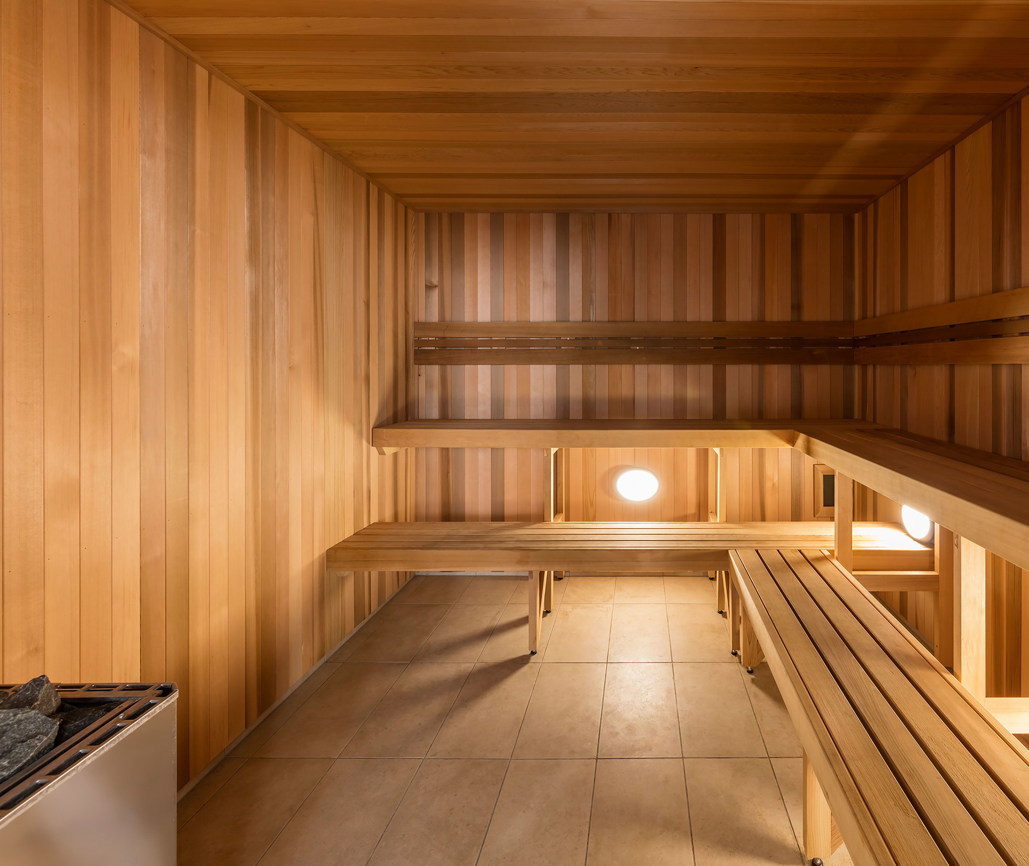 A sauna with wooden benches and a tiled floor.