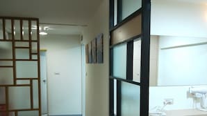 A hallway with a sliding door, a tiled floor, and a counter with a hairdryer. - Fu Ao Wo & Hostel (Nangan)