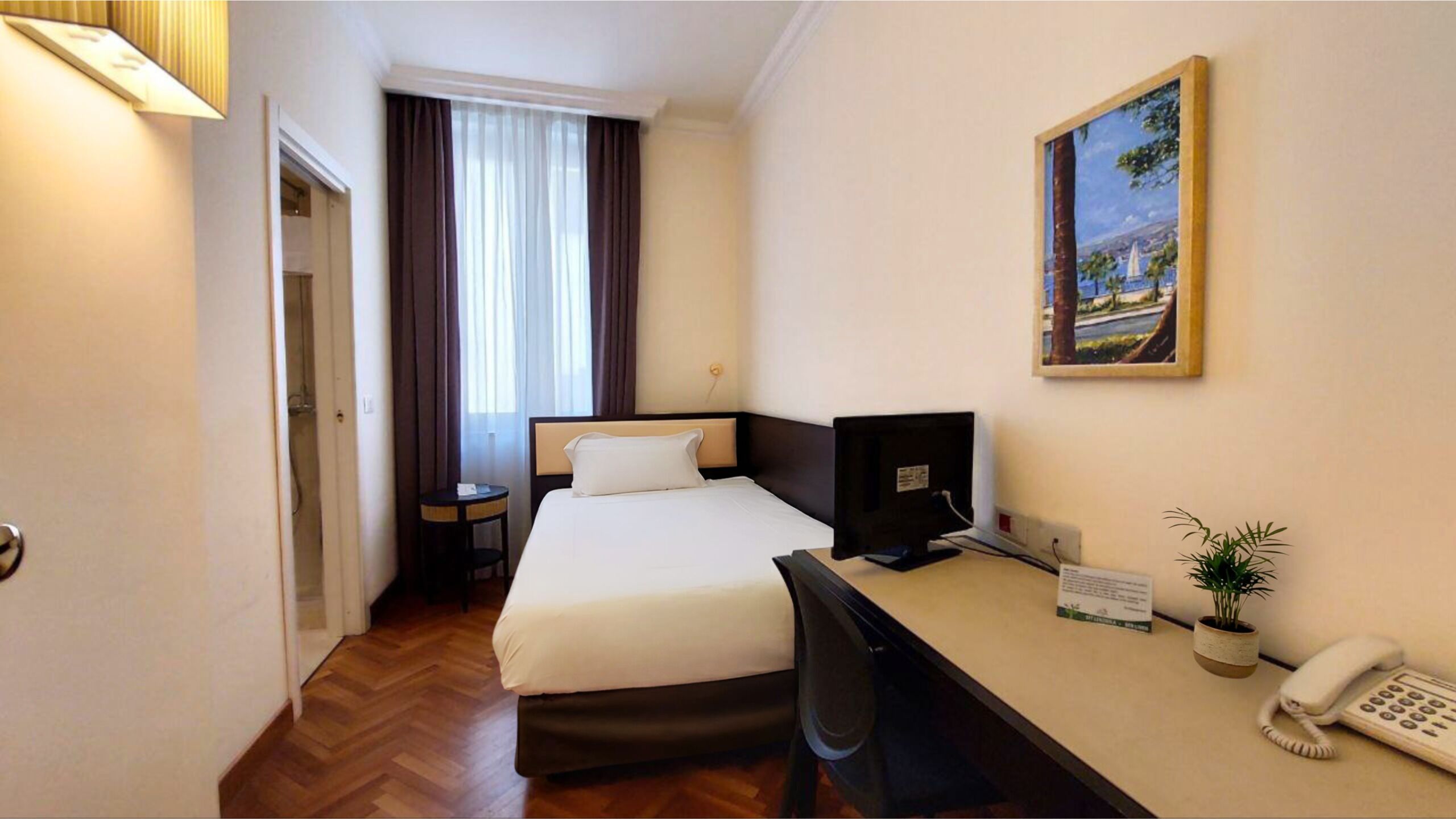 Eenpersoonskamer | Een minibar, een kluis op de kamer, een bureau, een laptopwerkplek