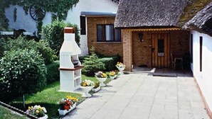 A courtyard with a thatched-roof building, a white structure with a chimney, and a brick house. - Haus Ückeritz Bauernsuite - Haus Ückeritz Bauernsuite (Ückeritz)