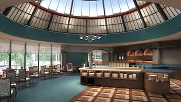 A spacious indoor area with a central island, seating arrangements, and a high ceiling with skylights.