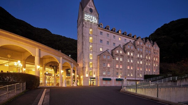 A hotel with a prominent tower, multiple floors, and a well-lit entrance. - Hotel Lorelei (Sasebo)