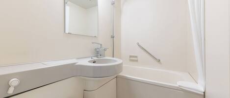 A modern bathroom with a sink, mirror, shower, and grab bar.