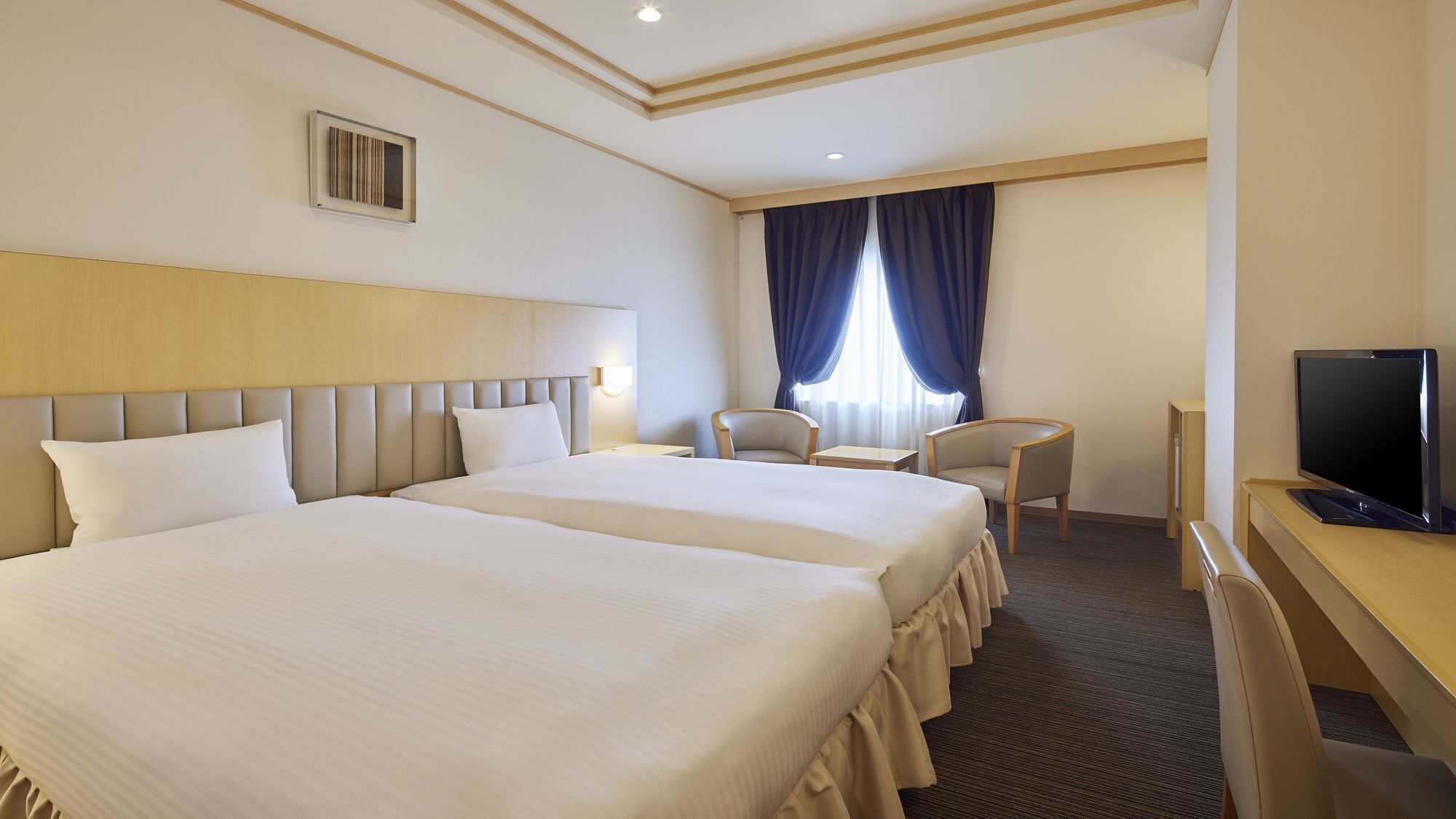 A hotel room with two beds, a desk, a chair, a television, and a window with curtains.