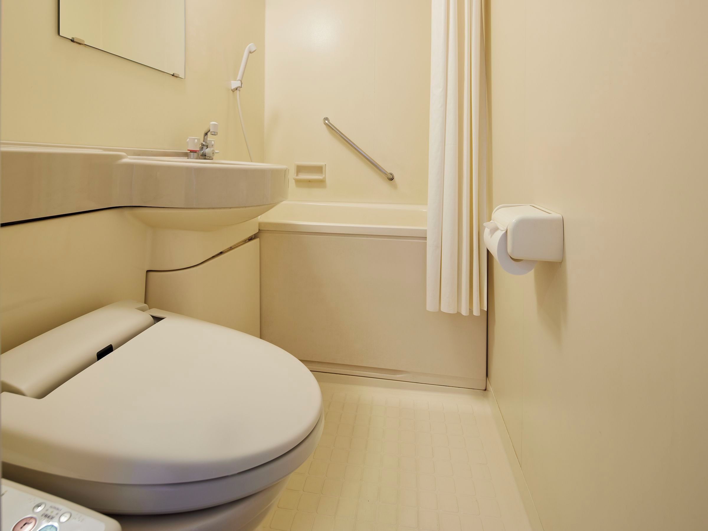 A small, modern bathroom with a toilet, sink, and shower.