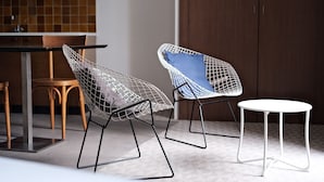 Two wireframe chairs with cushions, a round white table, and a wooden chair in a modern kitchen setting. - Résidence Le Beau Rivage (Bandol)