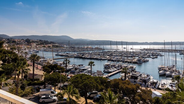 A marina with numerous boats docked, surrounded by greenery and buildings. - Résidence Le Beau Rivage (Bandol)
