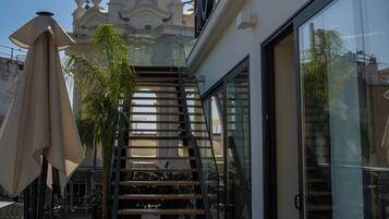 Entrada de un hotel con una escalera que lleva a un edificio blanco con cúpula.