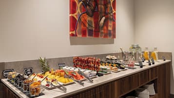 Un buffet proposant une variété d’aliments et de boissons, notamment des fruits, des légumes et des produits laitiers.