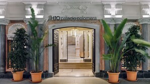 A grand entrance with a sign reading "H1O palacio colombera". - H10 Palacio Colomera (Córdoba)