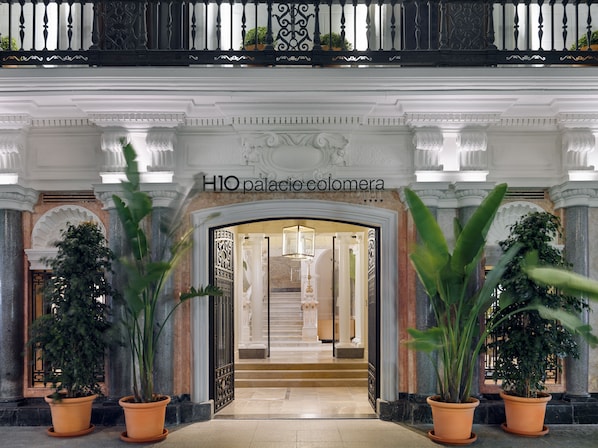 A grand entrance with a sign reading "H1O palacio colombera". - H10 Palacio Colomera (Córdoba)