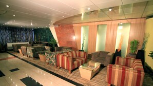 A lobby with multiple seating areas, including sofas and armchairs, arranged around a central coffee table. - Hotel La Vinci (Dhaka)