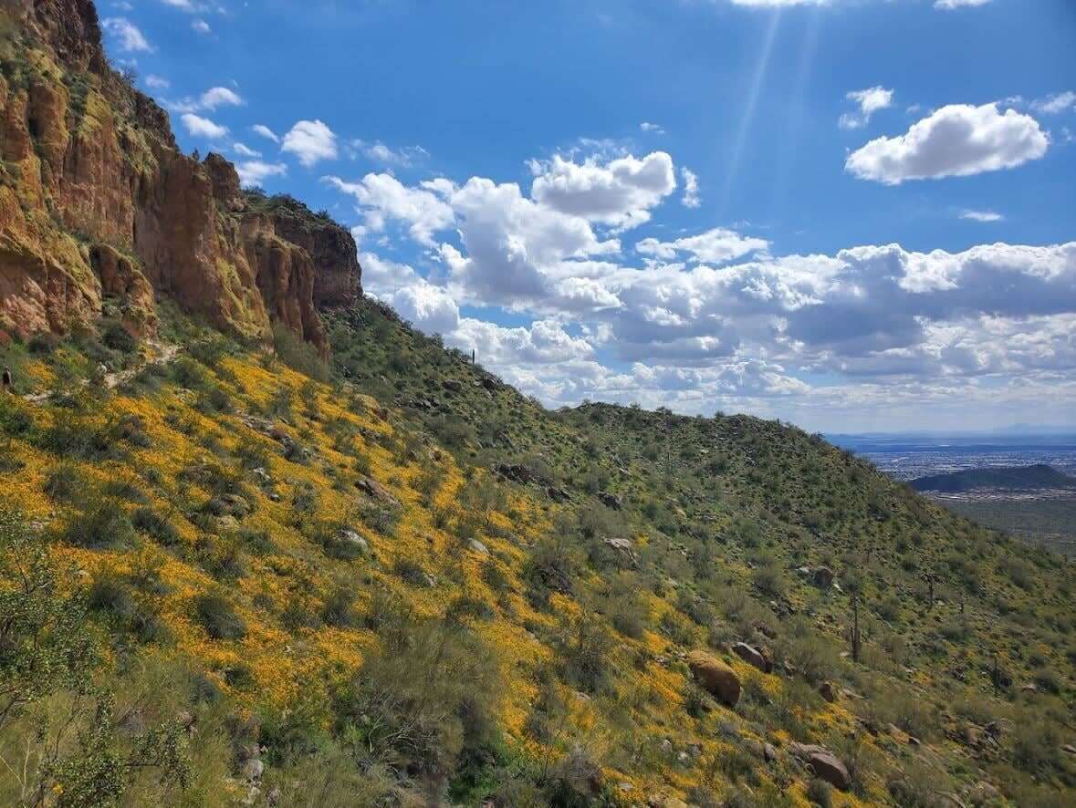 Un paysage montagneux, avec un ciel dégagé et quelques nuages épars.