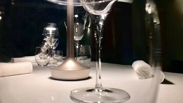 Una mesa dispuesta con varias copas de vino y un candelabro en el centro.