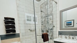Un bagno moderno con box doccia in vetro, un water e un mobile lavabo con specchio.