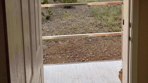 An open door leading to a balcony with a view of a desert landscape and distant mountains. - Cactus Corazón: Comfortable, Spacious & Secluded (Alpine)
