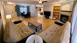 A living room with a sofa, a coffee table, a TV, and a fireplace. - Cactus Corazón: Comfortable, Spacious & Secluded (Alpine)