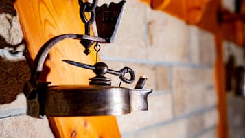 Un objeto metálico fijado a la pared, quizás una herramienta o adorno decorativo, frente a un muro de ladrillo con detalles de madera.