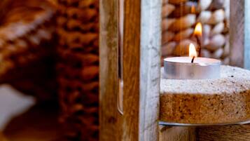 A candle in a glass holder on a wooden surface.