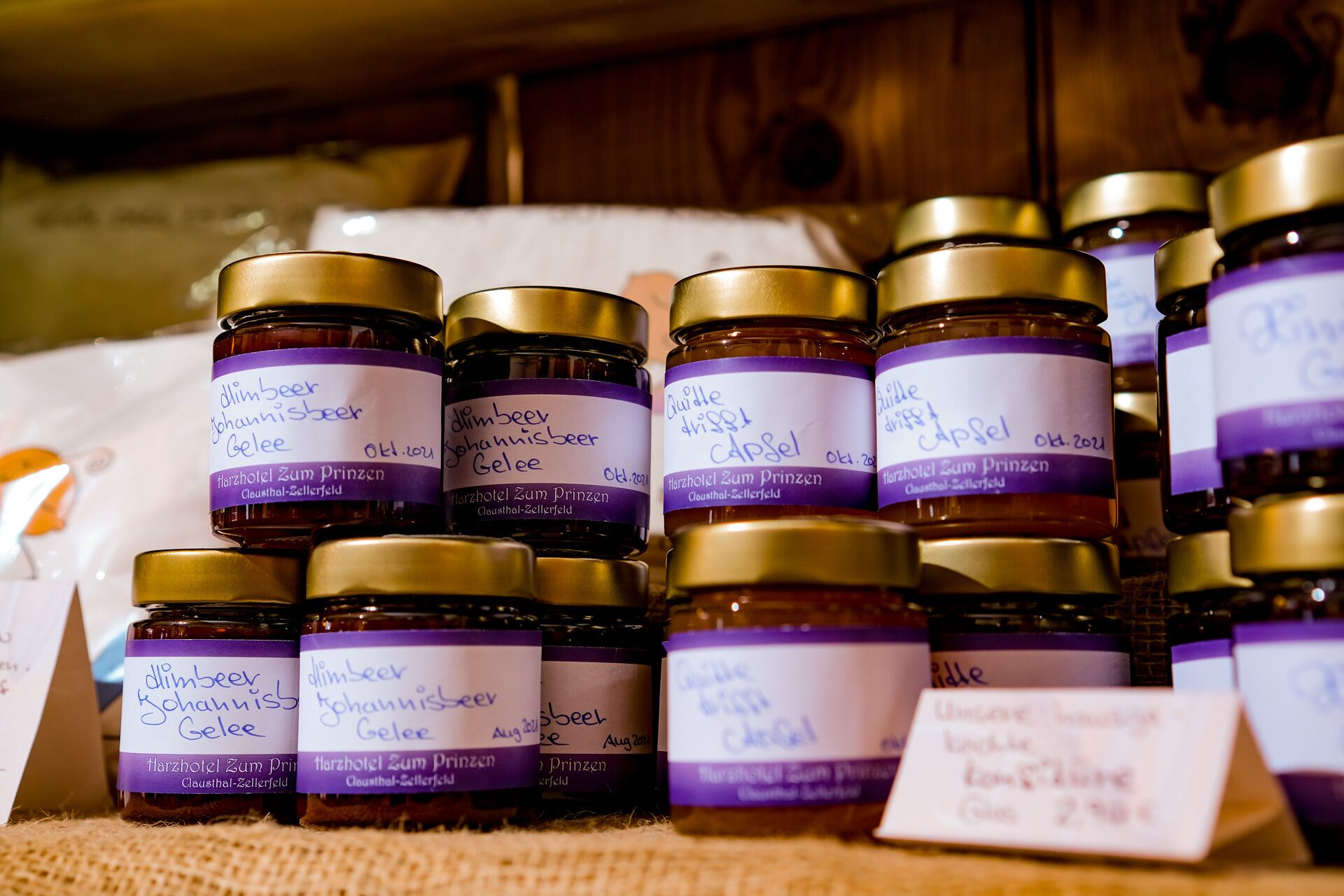 Multiple jars of dimble beer with handwritten labels, arranged on a wooden surface.