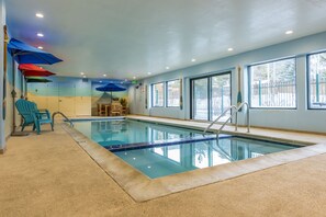 An indoor swimming pool with clear blue water, surrounded by windows and a concrete floor. - Top floor condo, mountain views, steps to village, free shuttle, 1 min to slopes (Keystone)
