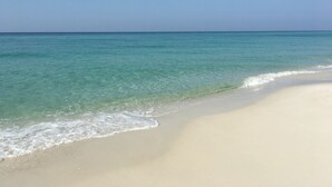 A beach with clear turquoise water and a sandy shore. - Amazing Beachfront Condo in the heart of Destin - w/FREE Beach Setup March-Oct (Destin)
