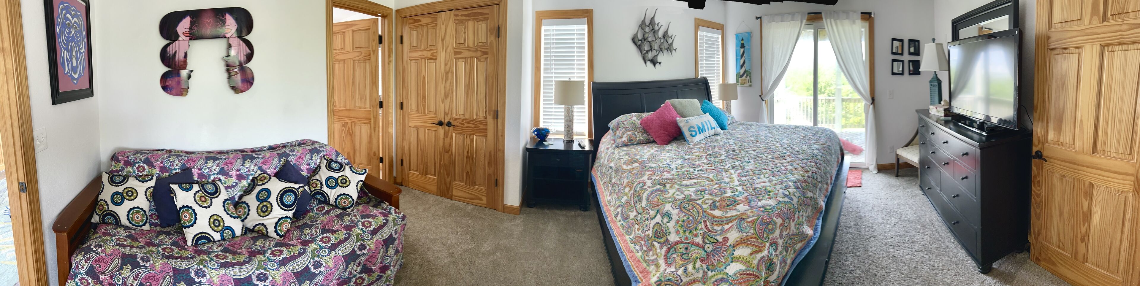 Un dormitorio con dos camas, armarios de madera, un televisor y una ventana con cortinas.