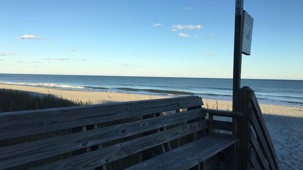 A wooden bench overlooking a beach with a clear sky. - Professionally Decorated,100 Yards to Beach, Shared Pool (Surfside Beach)