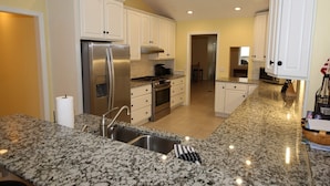 A modern kitchen with granite countertops, stainless steel appliances, and white cabinetry. - A Second Wind! With Sliding board/diving board!! (Huddleston)