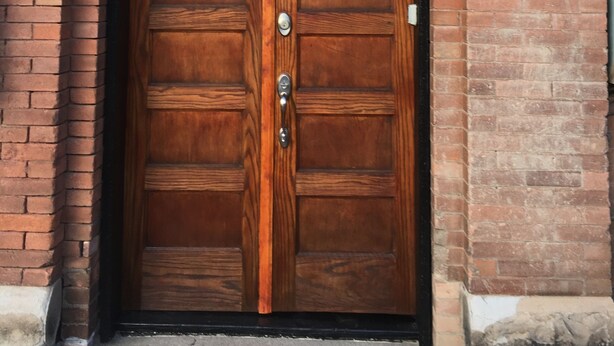A wooden double door with a glass panel above it, set in a brick wall. - Studio Loft in historic Silverton Building (Silverton)