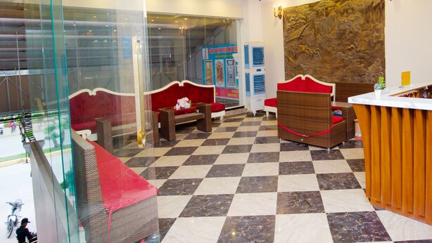 A hotel lobby with checkered flooring, seating areas, ceiling fans, and a reception desk. - Phu Thanh Sea View Hotel (Hai Phong)