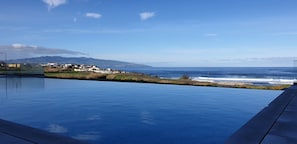 Una piscina con vista sull'oceano e su una catena montuosa in lontananza.