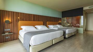 Een moderne hotelkamer met twee bedden, een houten accentmuur, een spiegel en uitzicht op de stad.