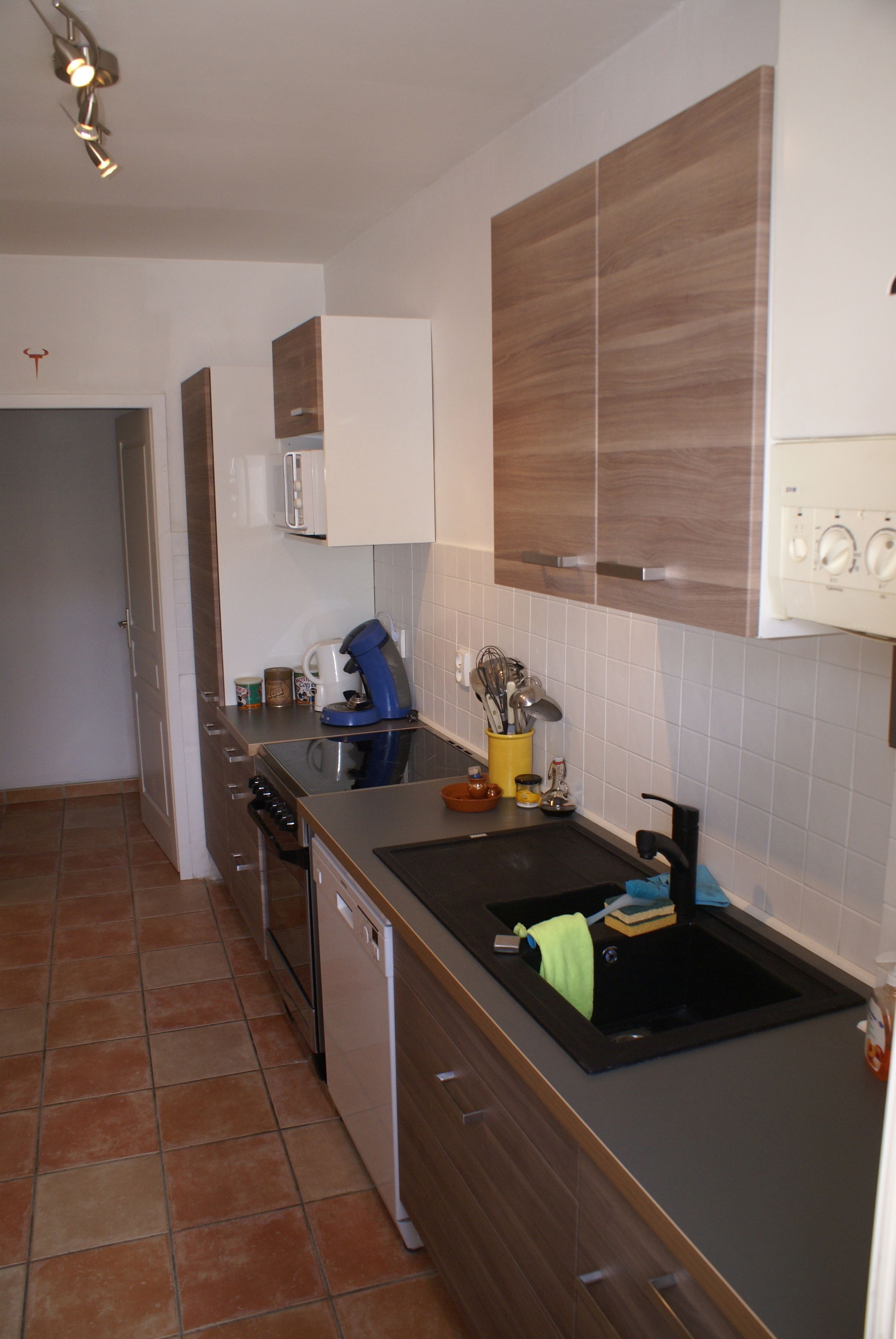 A modern kitchen with a dishwasher, stove, and a sink with a towel.