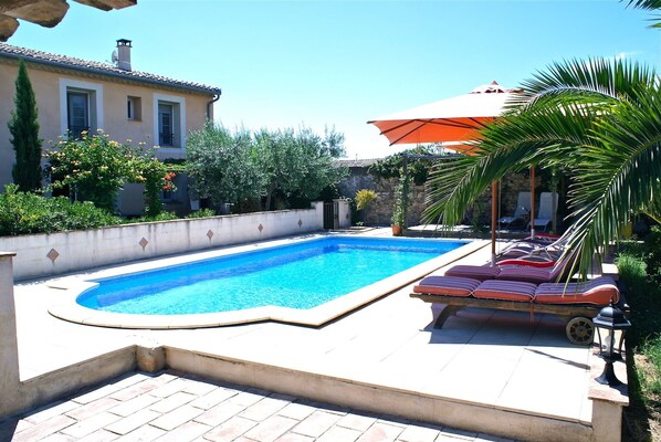 Alberca al aire libre y camastros 