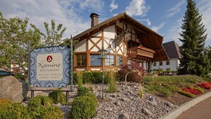 A traditional chalet-style building with a sign for 'Kamino Restaurant' indicating it offers tapas, bar, terrace, and events. - Kamino (Häusern)