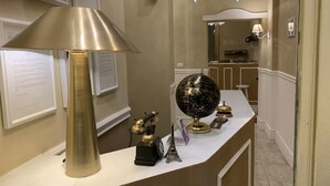 A reception desk with a globe, a telephone, and a lamp. - Boutique Hotel Calais Milano (Milan)