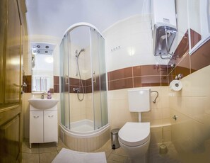 Un baño con ducha de vidrio, lavabo, inodoro y bidé.