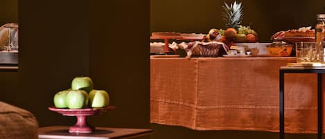 A dining table with a variety of fruits and a bottle of water.