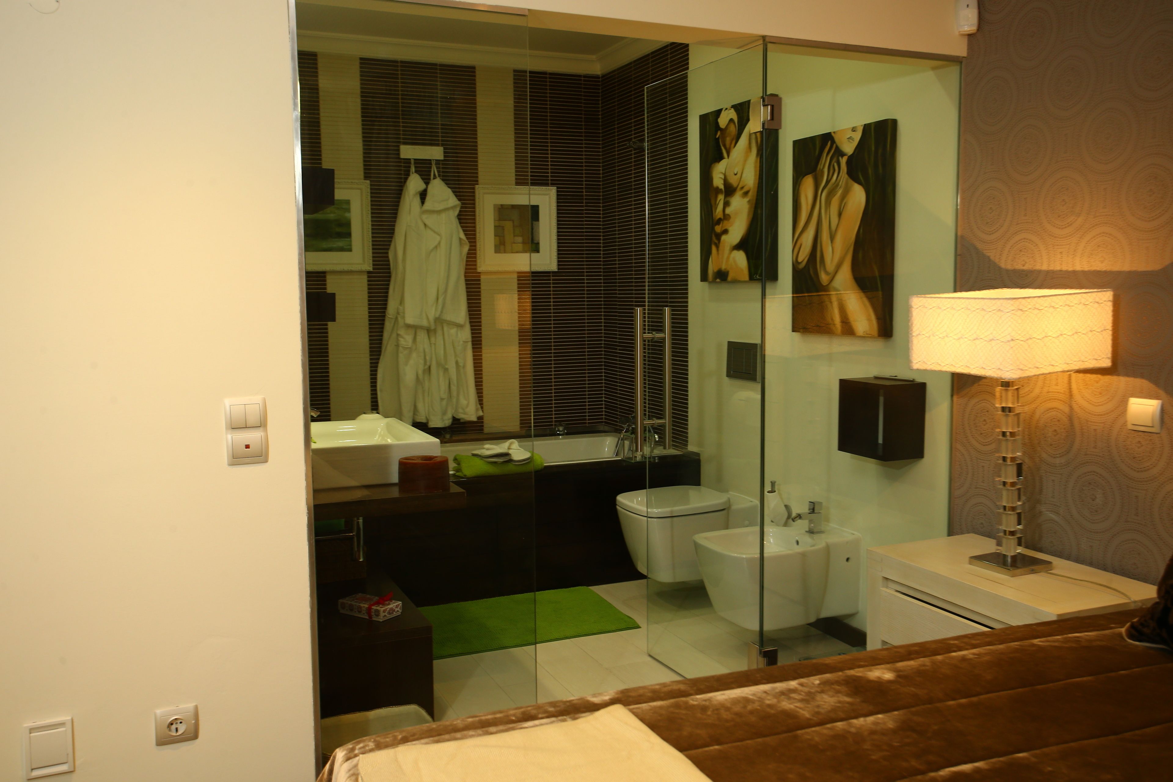 A modern bathroom with a glass shower enclosure, a bathtub, a toilet, and a sink.