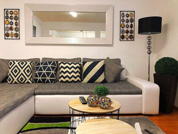 A modern living room with a sectional sofa, a round coffee table, and a floor lamp.
