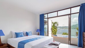 Ein Hotelzimmer mit einem großen Bett, Meerblick und einem Balkon.